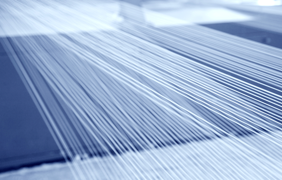 A close-up of stretched threads illustrates the importance of fire protection for fabrics.
