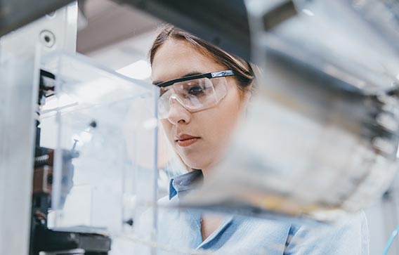 A woman in a lab coat and goggles at a workbench illustrates excellent hazard assessment for Exolit® OP flame retardants