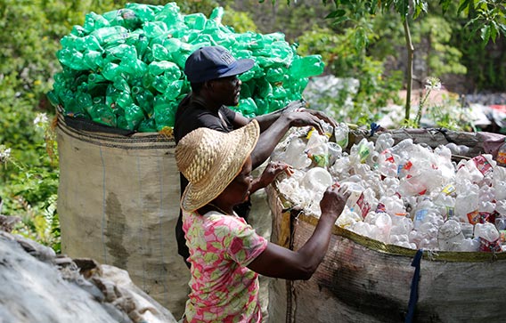 Two people collect ocean-bound plastic (OBP) waste of the type Clariant and Lavergne recycled for their flame-retarded PET compound used in electric and electronic equipment.