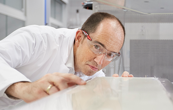 Technician in lab coat checks quality of epoxy material fire-protected with Clariant’s special Exolit® EP flame retardants.