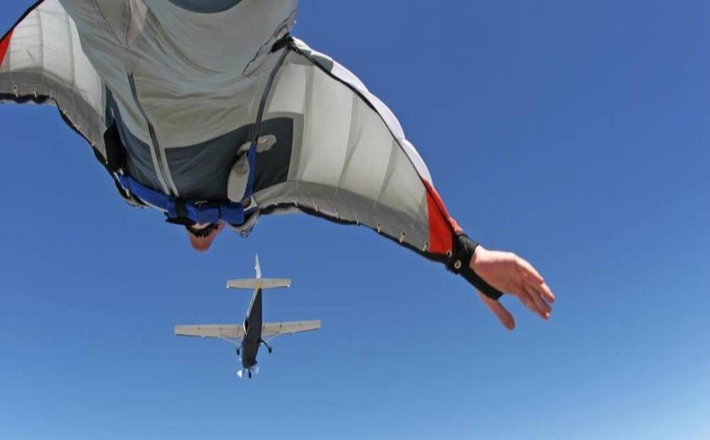 Sky Diver with above flying airplane and blue sky