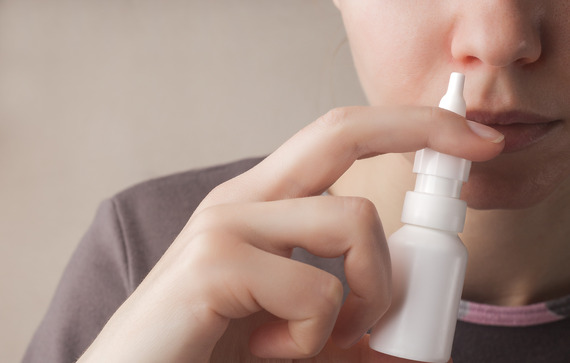 Image A Woman With a Runny Nose Holds a Medicine In Her Hand