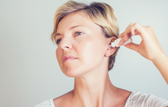 Image Woman Using Ear Drops On Gray Background